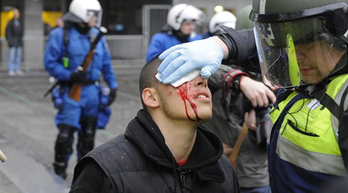 Ein Polizist versorgt einen Verletzten während der Nachdemonstration.